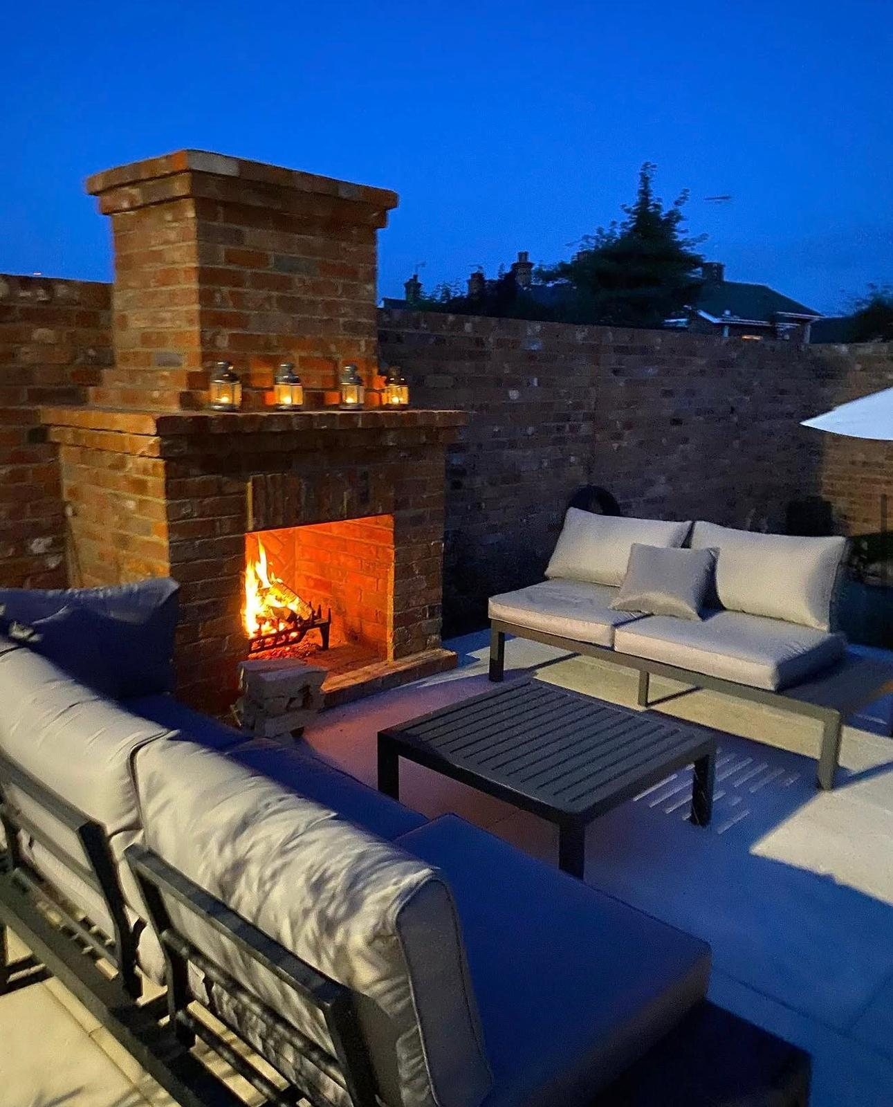 Walled terrace with an outdoor brick fireplace